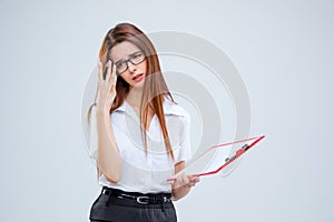 The young business woman with pen and tablet for notes on gray background