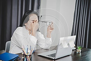 Young business woman person sleepy and has frustration eye problems with cephalalgia disease from using laptop computer on her photo