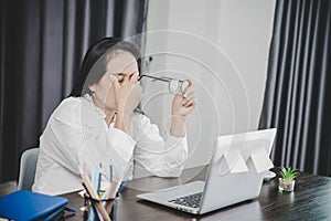 Young business woman person sleepy and has frustration eye problems with cephalalgia disease from using laptop computer on her