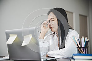 Young business woman person sleepy and has frustration eye problems with cephalalgia disease from using laptop computer on her photo