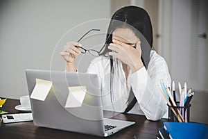 Young business woman person sleepy and has frustration eye problems with cephalalgia disease from using laptop computer on her photo