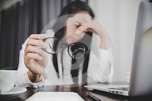 Young business woman person sleepy and has frustration eye problems with cephalalgia disease from using laptop computer on her photo