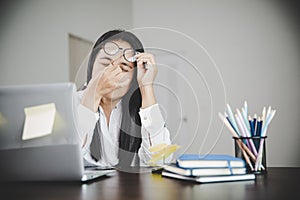 Young business woman person sleepy and has frustration eye problems with cephalalgia disease from using laptop computer on her