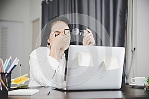 Young business woman person sleepy and has frustration eye problems with cephalalgia disease from using laptop computer on her