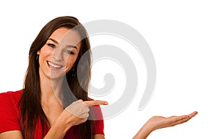 Young business woman pointing to copy space, showing a product i