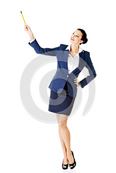 Young business woman pointing up with pen.