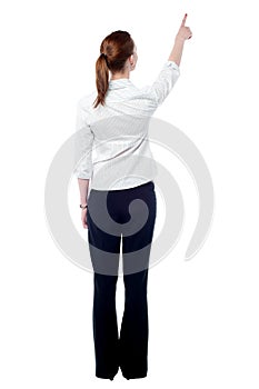 Young business woman pointing at wall