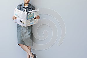 Young business woman reading newspaper