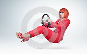 Young business woman in red and glasses driver car with a wheel, auto lady concept.