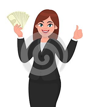 Young business woman showing/holding bunch of money, cash, dollar, currency, banknotes in hand and gesturing, making thumbs up.