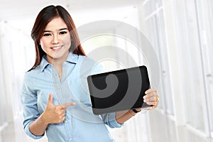 Young business woman showing tablet screen