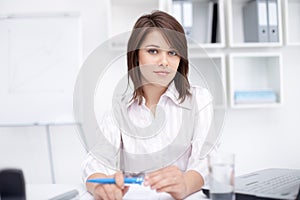 Young business woman sitting at desk at office