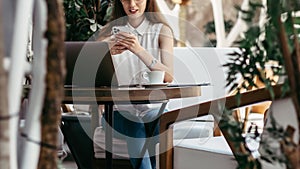 young business woman with a smartphone taking notes in her notebook.