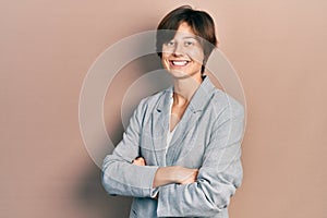 Young business woman smiling happy and confident with crossed arms standing over isolated background