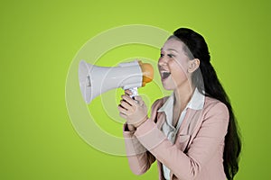 Young business woman speaking with megaphone