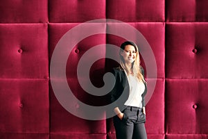 Young Business Woman Standing Against Burgundy Wall Panels