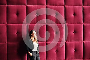 Young Business Woman Standing Against Burgundy Wall Panels