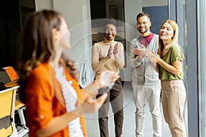 Young business woman standing in front of her team at the office