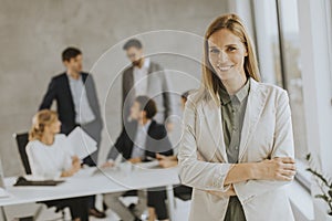 Young business woman standing in the office in front of her team