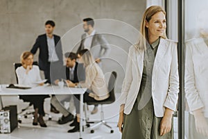 Young business woman standing in the office in front of her team