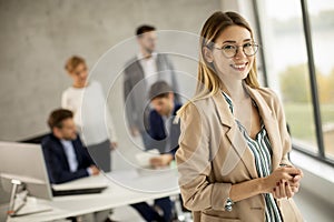 Young business woman standing in the office in front of her team