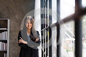 Young business woman standing to drinking coffee and thinking about the strategy of new startup while looking out the