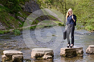 Young business woman stepping stones to success metaphor