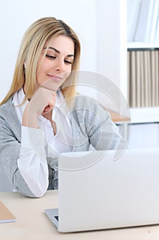 Young business woman or student girl sitting at office workplace with laptop computer. Home business concept