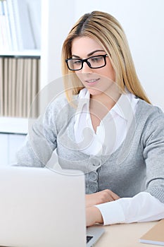 Young business woman or student girl sitting at office workplace with laptop computer. Home business concept