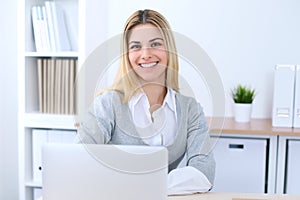 Young business woman or student girl sitting at office workplace with laptop computer. Home business concept