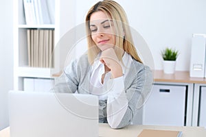 Young business woman or student girl sitting at office workplace with laptop computer. Home business concept