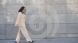Young business woman in suit going on street to meeting in office. Confident businesswoman walks near modern building