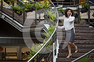 Young business woman talking on mobile phone standing outdoors.