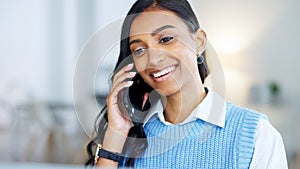 Young business woman talking on a phone call in an office. Confident designer smiling while communicating in a