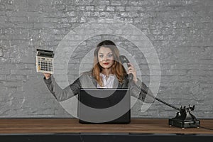 Young business woman talking on the phone, holding calculator in her hand