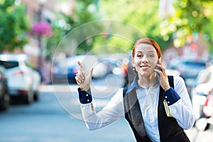 Young business woman talking on smart phone, hails taxi cab