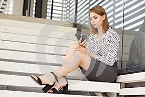 Young business woman texting on her smart phone