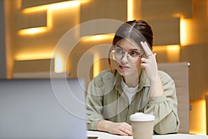 Young business woman thinks with her head at the workplace, thinking modern