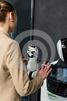 young business woman touching robot in