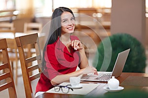 Young business woman uses laptop in cafe