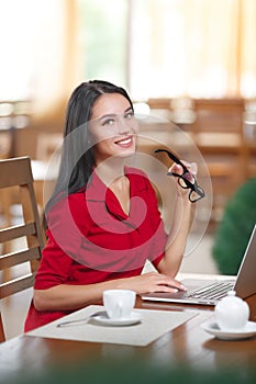 Young business woman uses laptop in cafe