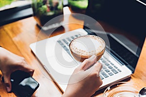 Young business woman is using his smart phone and The laptop computer