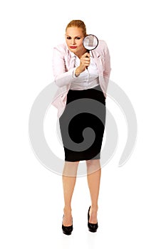 Young business woman using a magnifying glass