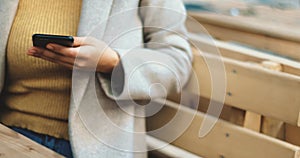 Young business woman using smartphone while doing job, typing text message on cell phone. Close-up