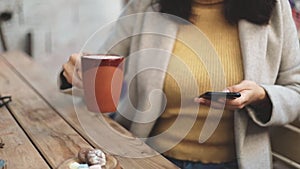 Young business woman using smartphone while doing job, typing text message on cell phone. Close-up