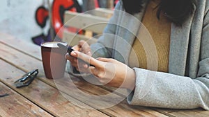 Young business woman using smartphone while doing job, typing text message on cell phone. Close-up