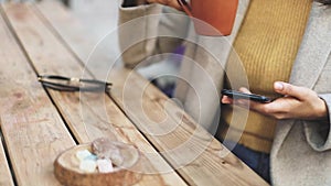 Young business woman using smartphone while doing job, typing text message on cell phone. Close-up