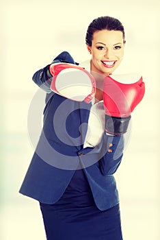 Young business woman wearing boxing gloves.