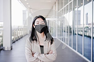 Young business woman wearing face mask in city. corona virus concept. eyes closed