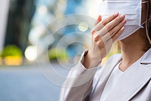 Young business woman wearing surgical mask coughing in public